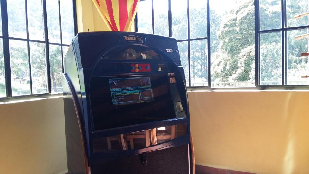 an arcade machine sitting in front of a window at Alla Arriba in Las Cruces