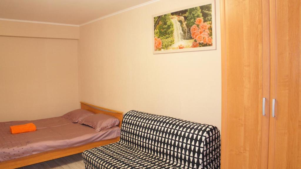 モスクワにあるApartments Presnenskiy Valのベッドルーム1室(ベッド1台、ソファ、椅子付)