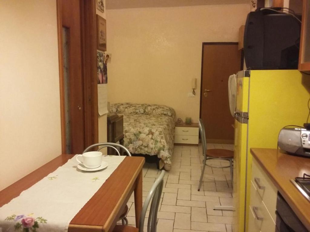 una piccola cucina con tavolo e una camera con letto di Monolocale Monteverde a Roma