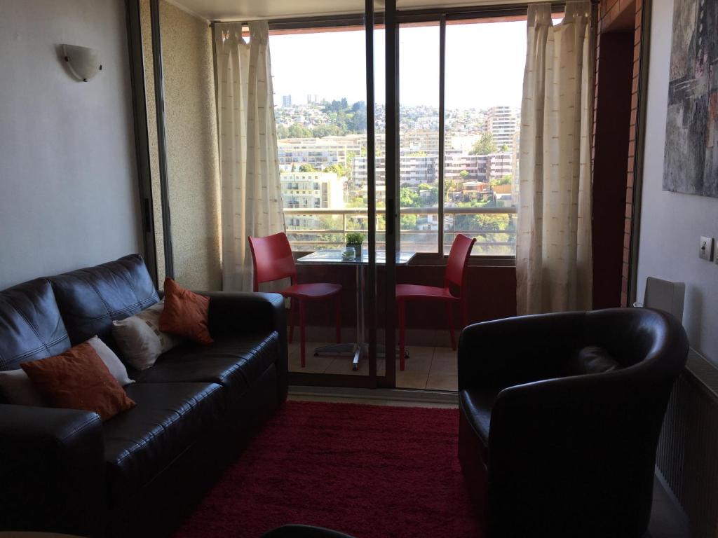 sala de estar con sofá, sillas y ventana en Departamento Suke, en Viña del Mar