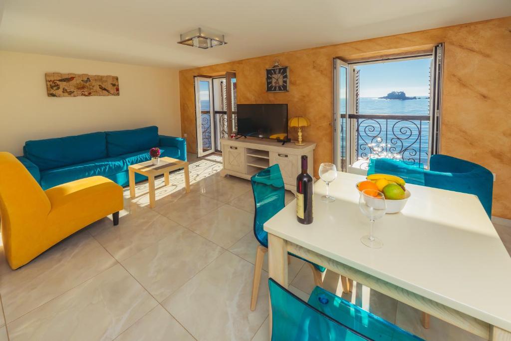 uma sala de estar com mobiliário azul e vista para o oceano em Apartments Galija Petrovac Lux em Petrovac na Moru