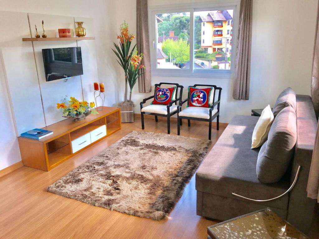 sala de estar con sofá y 2 sillas en Apartamento no Centro de Gramado, en Gramado