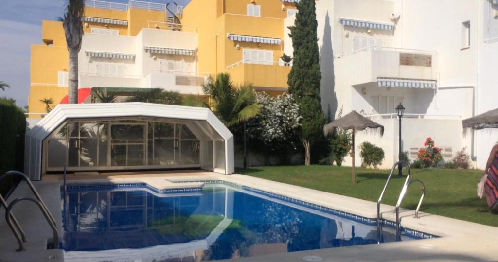 a swimming pool in front of a building at Arabella Naturist Apartment in Vera