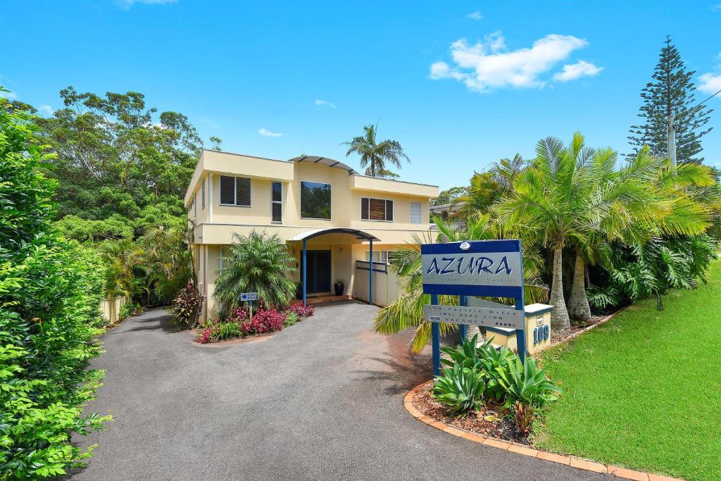 a house with a sign in front of a driveway at Azura Beach House B&B in Port Macquarie