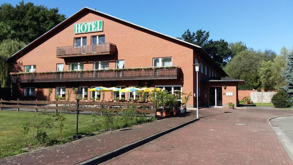 a hotel building with umbrellas in front of it at Hotel "An der Warthe" in Salzwedel