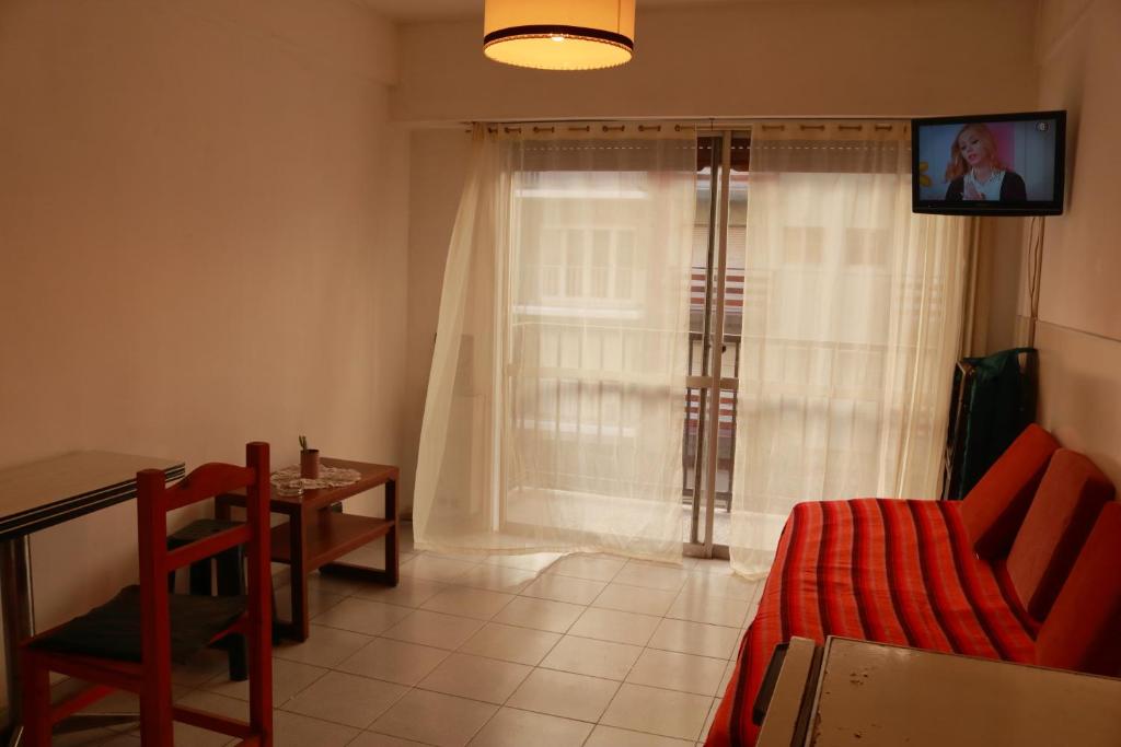 a living room with a couch and a table and a window at Ferbus monoambiente in Mar del Plata