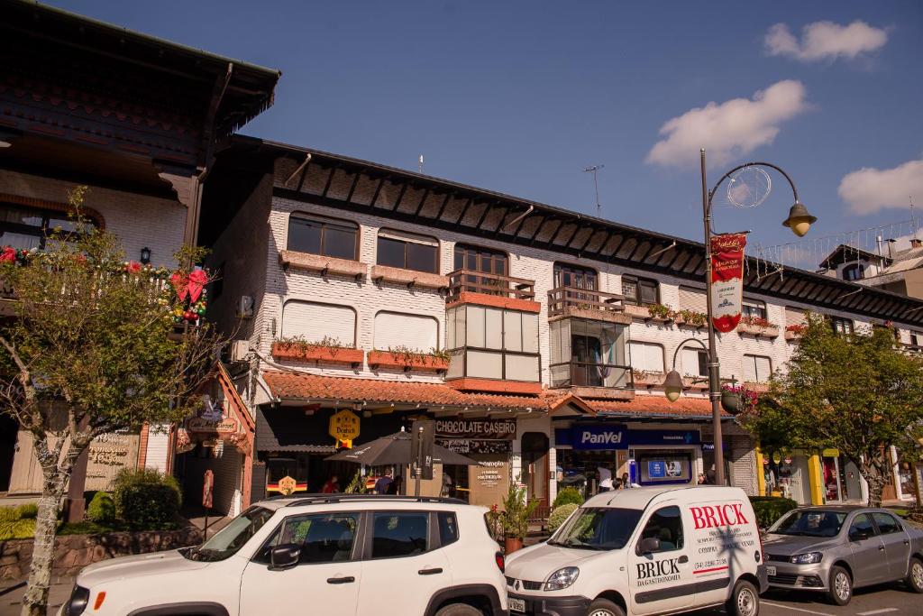 two white cars parked in front of a building at Hospedagem Vila Suiça Centro in Gramado