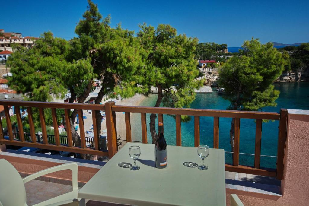 eine Flasche Wein auf dem Tisch auf dem Balkon in der Unterkunft Rooms Apostolis in Patitiri