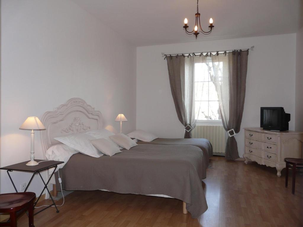 ein Schlafzimmer mit einem großen Bett und einem Fenster in der Unterkunft Hôtel Le Globe in Marsanne