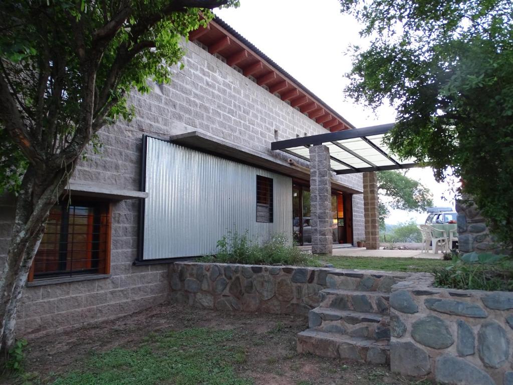 a brick house with a window and a stone wall at LA AGÜITA PERDIDA in Raco