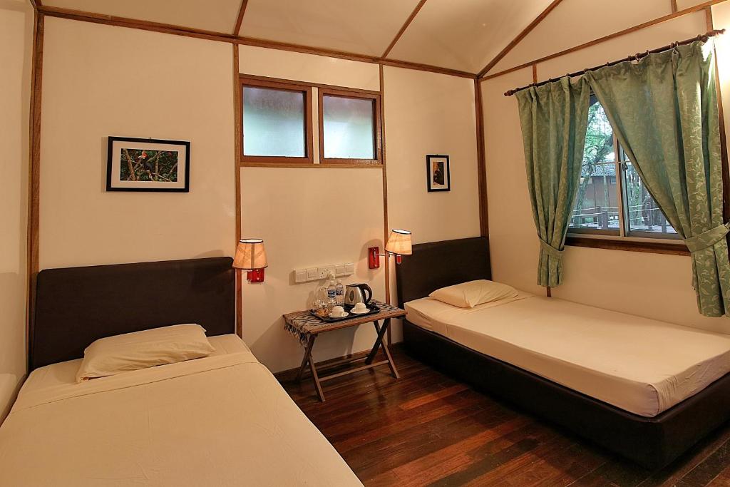 Un pat sau paturi într-o cameră la Nature Lodge Kinabatangan