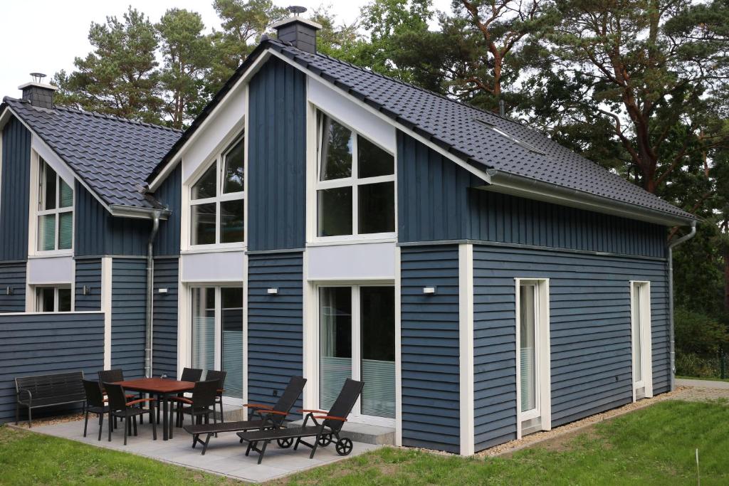 a blue and white house with a table and chairs at Strandhus Baabe Haus 3 in Baabe