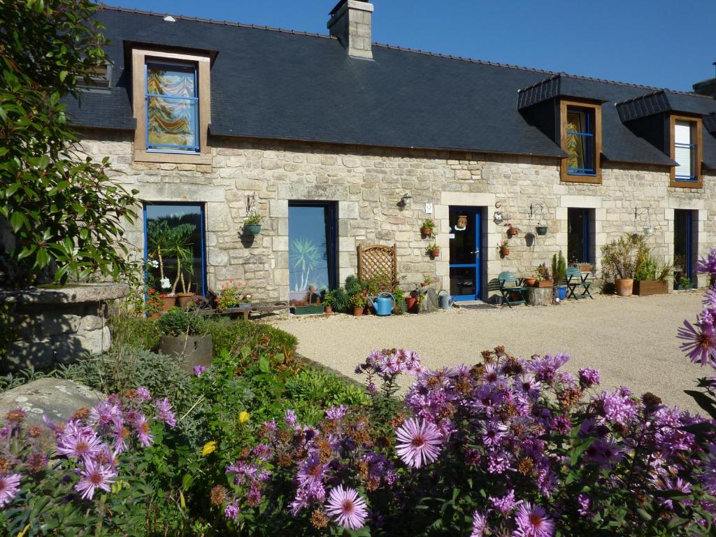 ein Steinhaus mit Blumen davor in der Unterkunft Ti Er Mad in Kernascléden