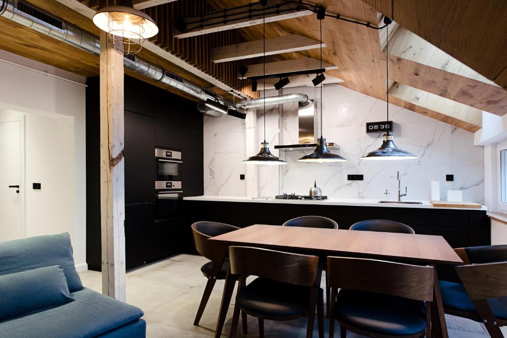 a kitchen and dining room with a table and chairs at Apartament Dębowy in Stronie Śląskie