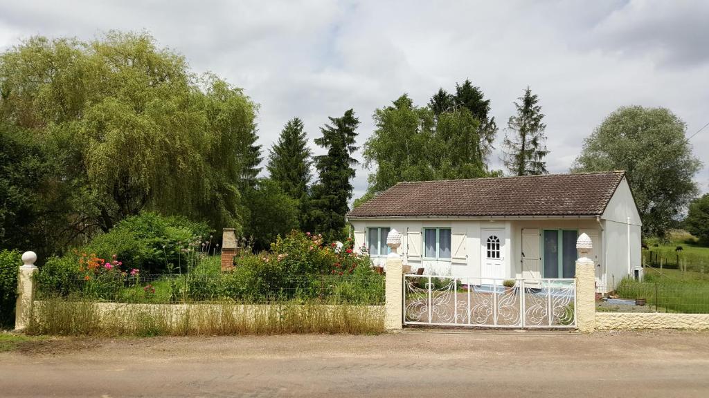 a white house with a gate in front of it at la ferme aux kangourous in Donzy