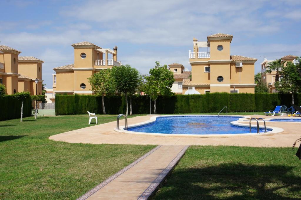 una piscina en un patio frente a una casa en villa las tres perlas, en Algorfa