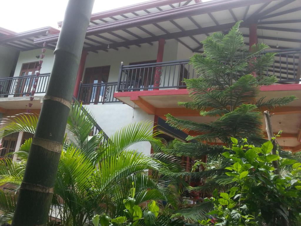 un edificio con una palmera frente a un edificio en Peacock Villa Resort en Udawalawe