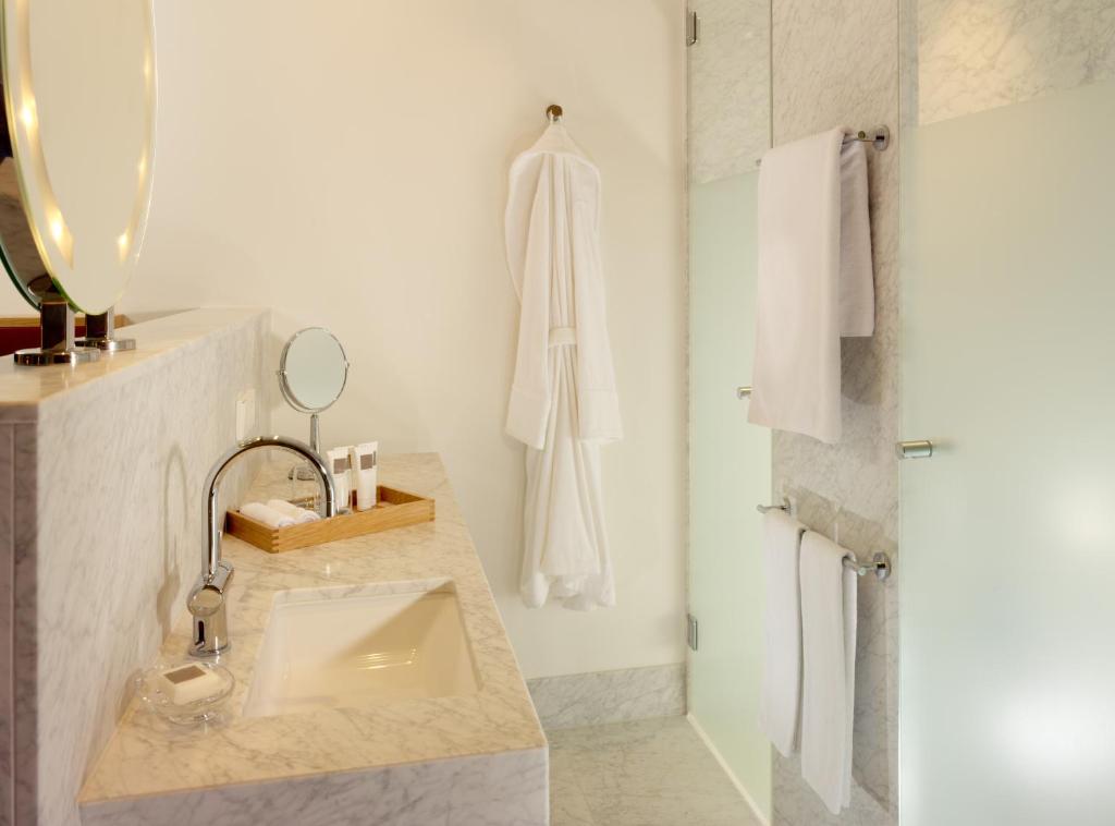 a bathroom with a sink and a shower at HYPERION Hotel Dresden Am Schloss in Dresden