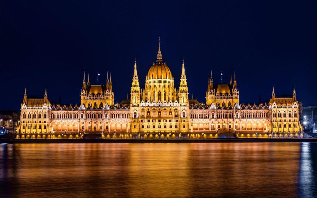 a lit up parliament building in london at night at Budapest Parlament Welcome Apartment in Budapest