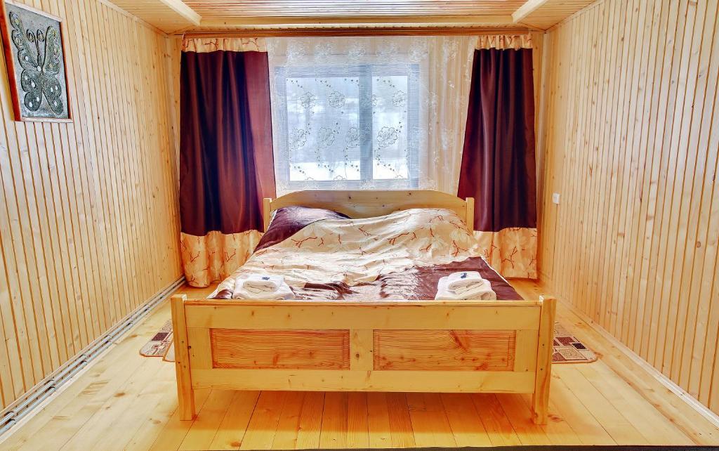 a bedroom with a bed in a room with a window at Medova Hata in Mykulychyn