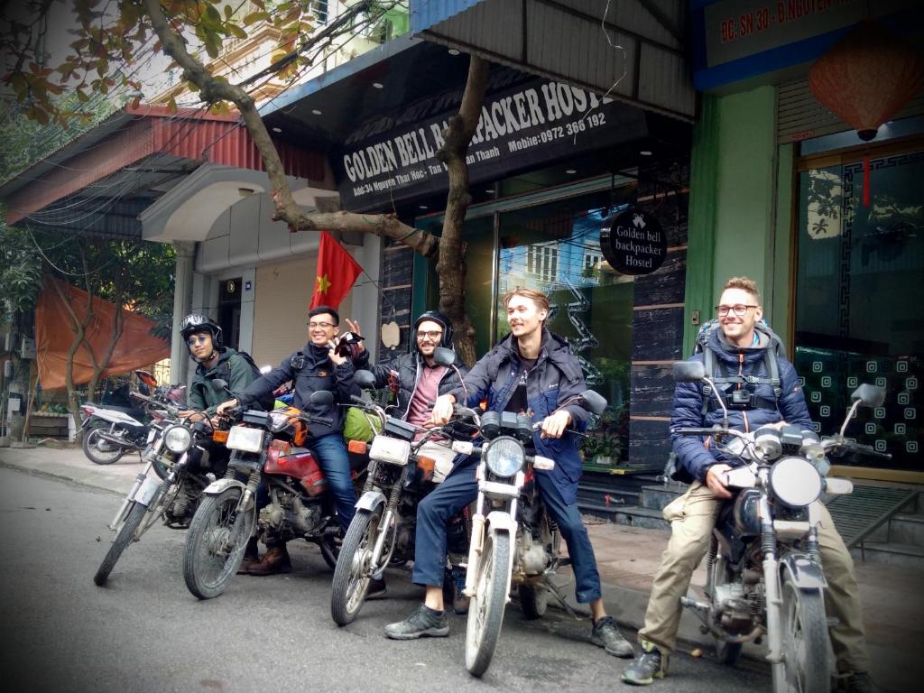 un grupo de hombres sentados en motocicletas frente a una tienda en Golden Bell Backpacker Hostel, en Ninh Binh