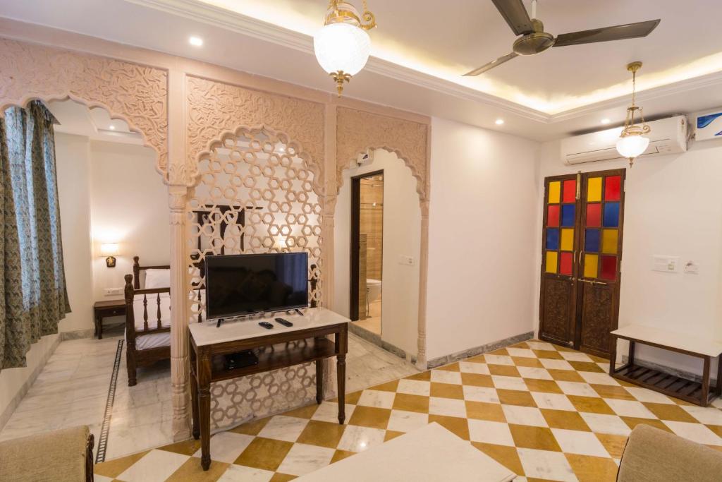 a living room with a tv on a wall at Pandya Niwas in Jaipur