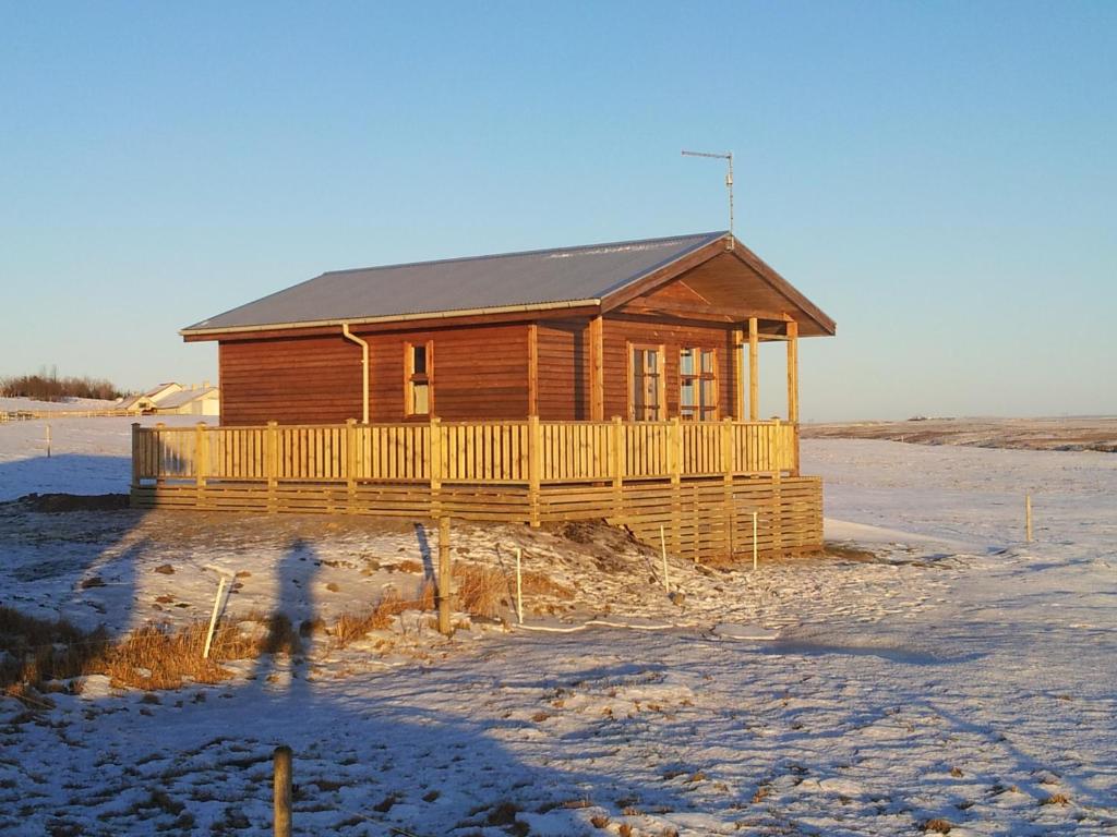 a wooden house in the middle of a field at Egilsstaðir 1 Guesthouse in Villingaholt