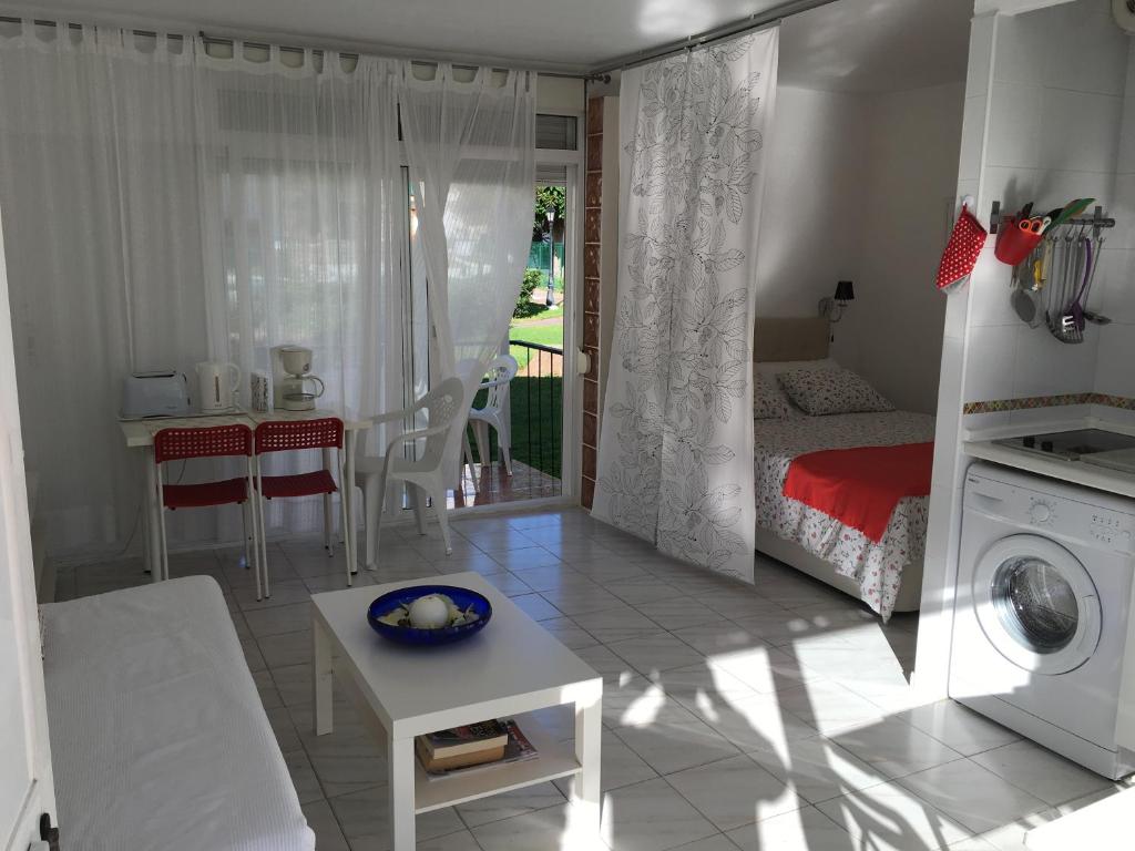 salon z łóżkiem i pralką w obiekcie Bungalow Aloha Torres w mieście Torremolinos