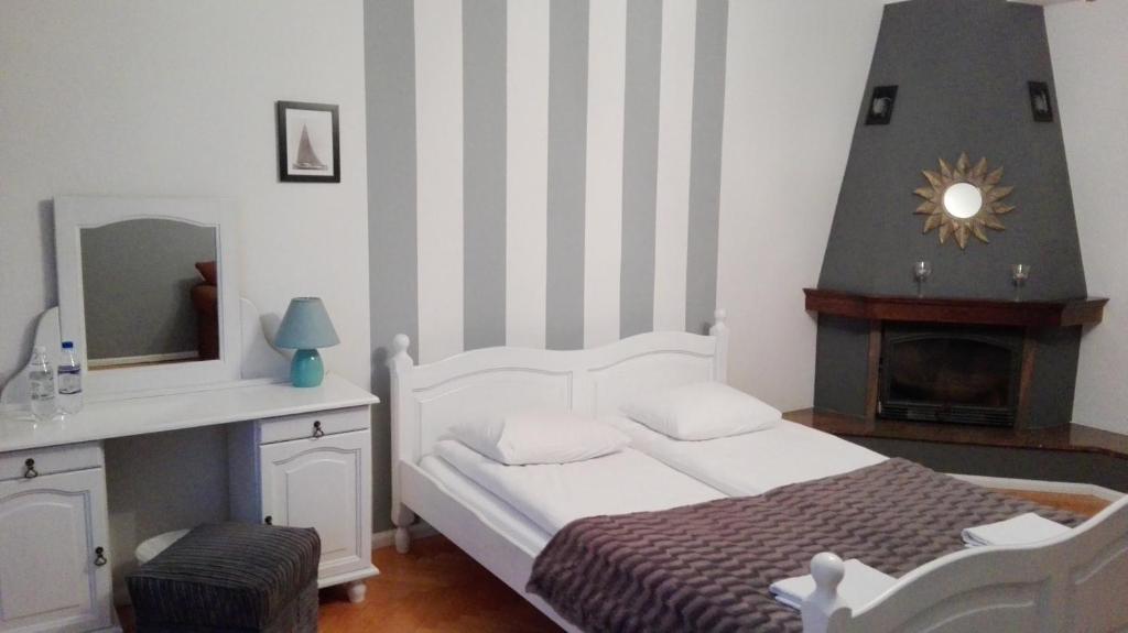 グディニャにあるMirka Apartmentのベッドルーム(白いベッド1台、暖炉付)