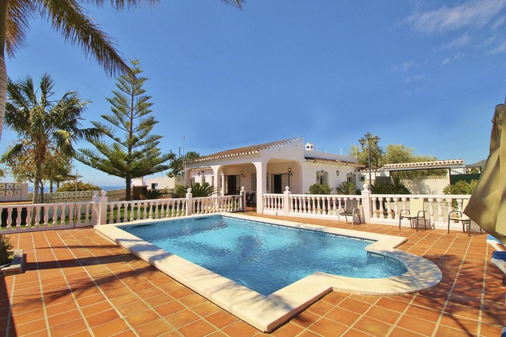 a swimming pool in front of a house at Villa Jeromo SpainSunRentals 1004 in Nerja