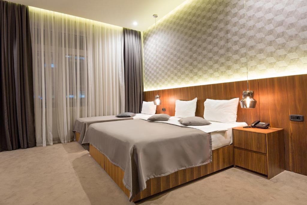 a hotel room with two beds and a window at Five Points Square - City Center in Belgrade