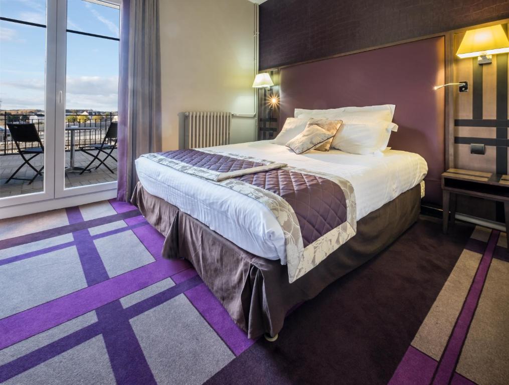 um quarto de hotel com uma cama e uma varanda em Hotel Bellevue em Amboise