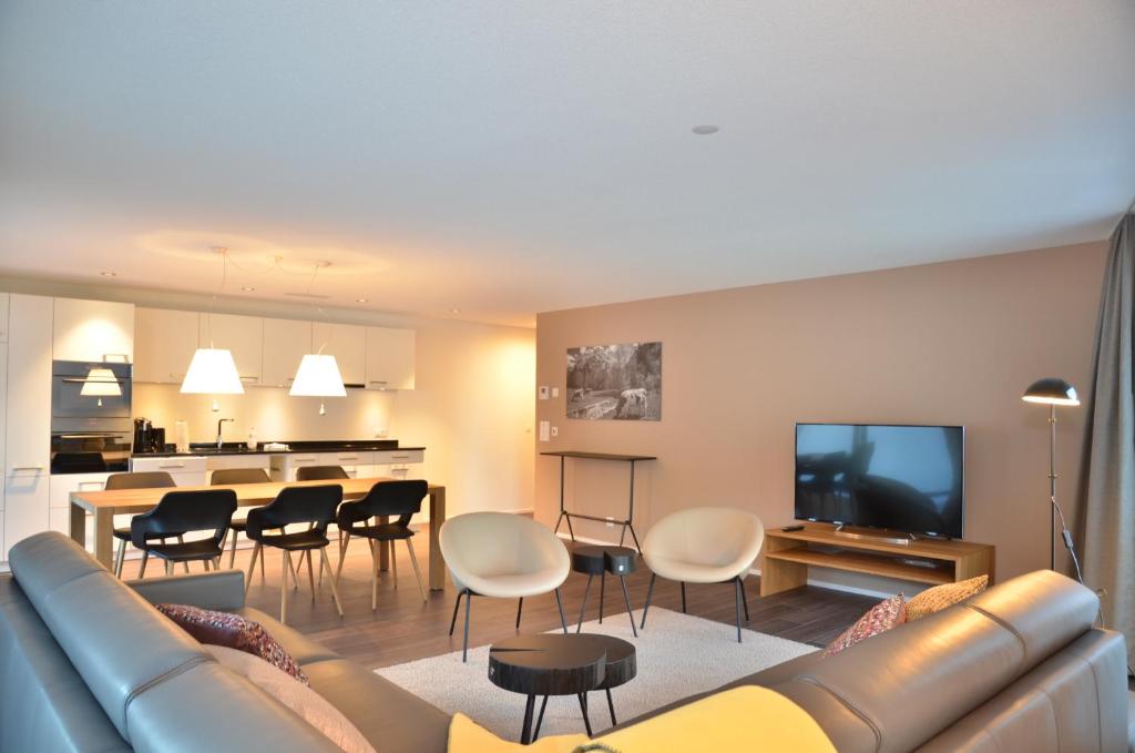 un soggiorno con divano e una sala da pranzo di Apartment Edelwyss - GriwaRent AG a Interlaken
