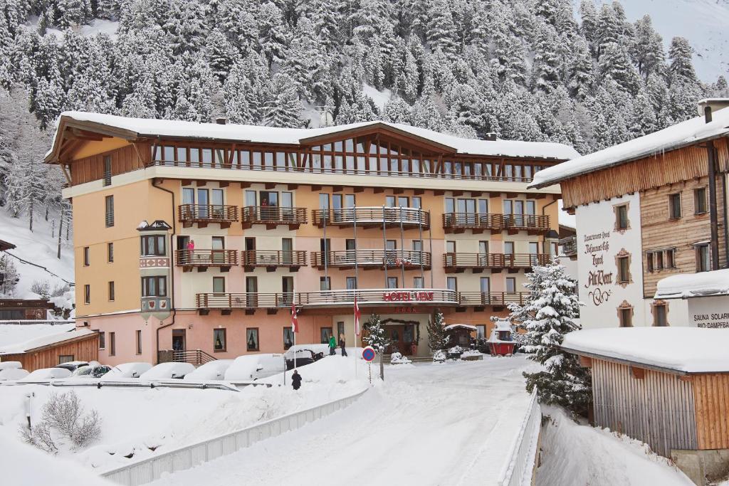 a large building in the snow in front of a mountain at Hotel Vent in Vent