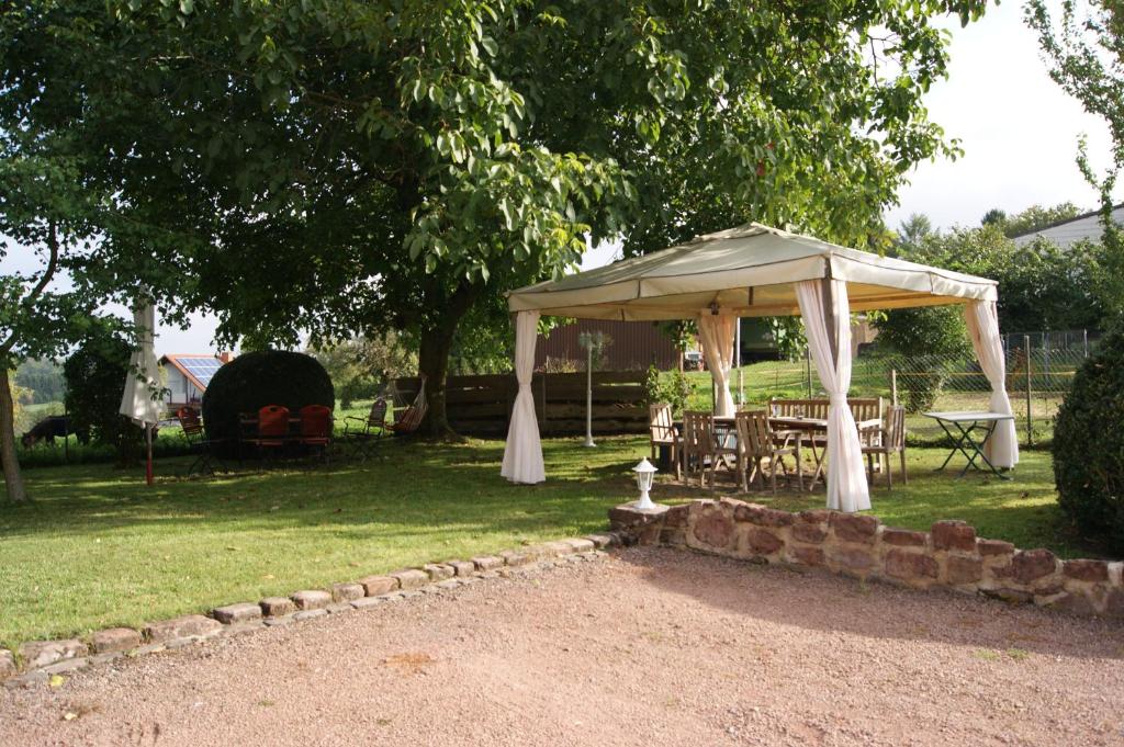 a gazebo with a table and chairs under it at Gästehaus &#39;Alte Bäckerei&#39; Kaffeehaus in Großbundenbach