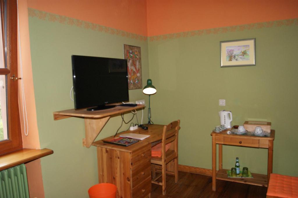 a living room with a desk with a tv and a computer at Gästehaus &#39;Alte Bäckerei&#39; Kaffeehaus in Großbundenbach