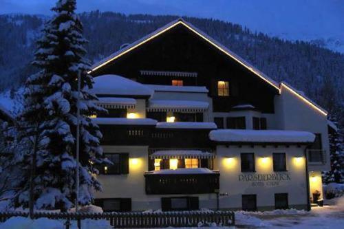 ein großes Gebäude mit einem Weihnachtsbaum davor in der Unterkunft Parseierblick in Sankt Anton am Arlberg