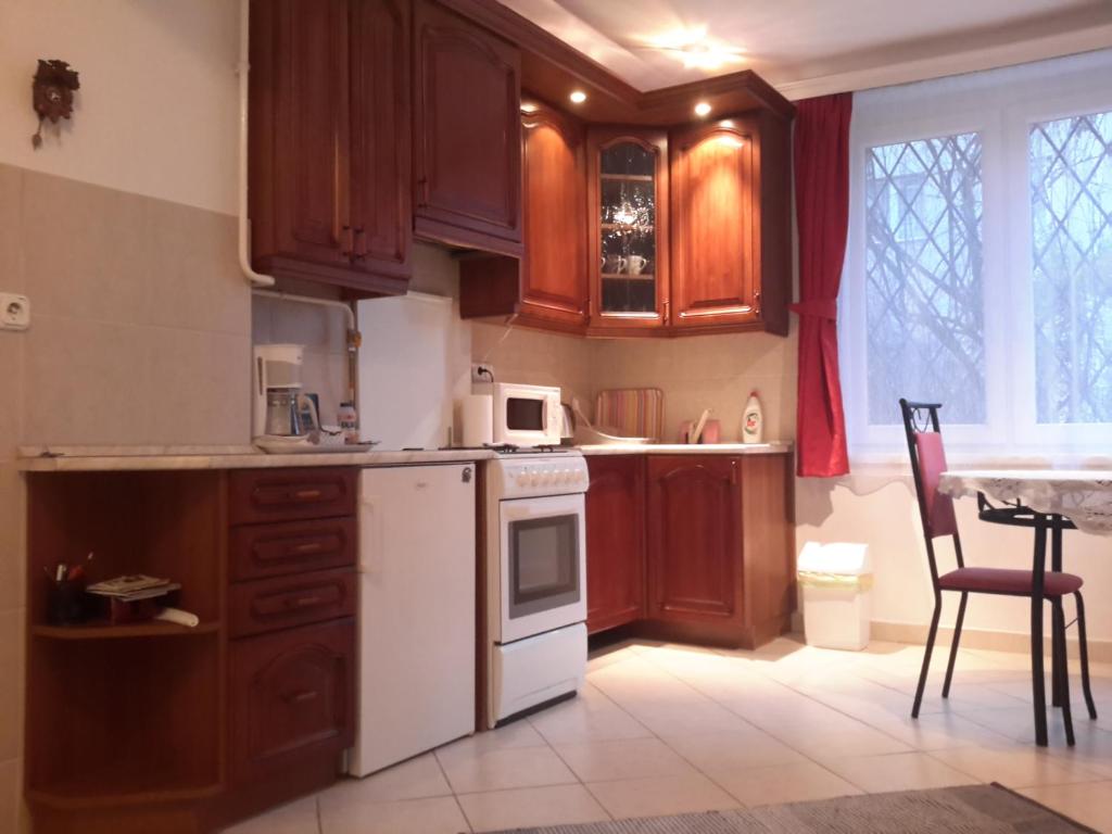 a kitchen with wooden cabinets and a white stove top oven at GERARDUS apartman in Budapest