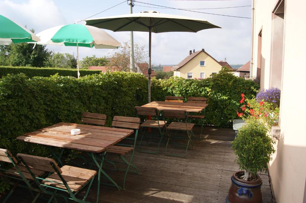 a patio with tables and chairs and an umbrella at Gästehaus &#39;Alte Bäckerei&#39; Kaffeehaus in Großbundenbach