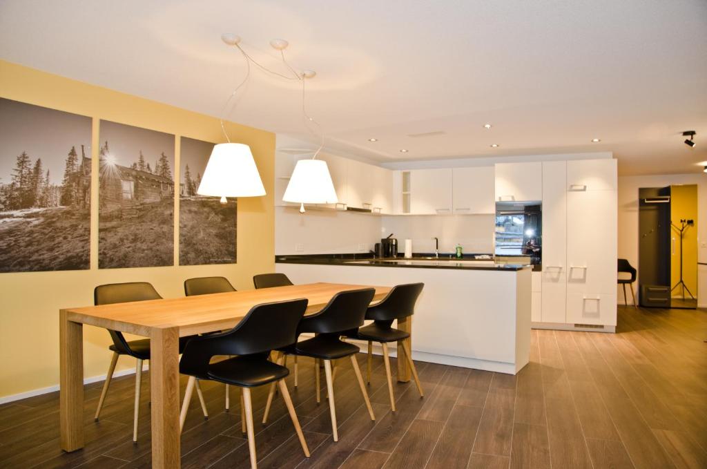a kitchen and dining room with a wooden table and chairs at Apartment Gänseblüemli - GriwaRent AG in Interlaken
