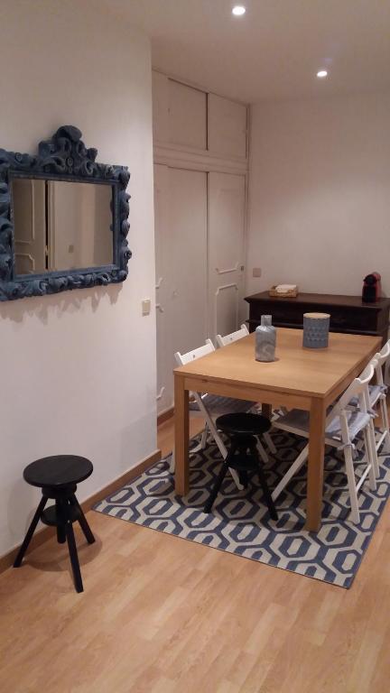 a dining room with a table and chairs and a mirror at Casa da Madrinha II in Monte Gordo
