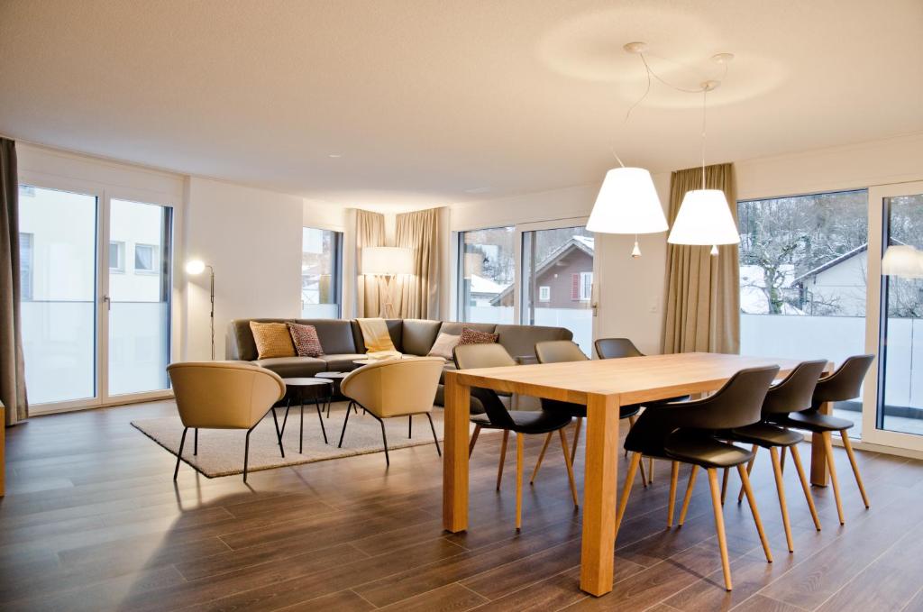 una sala da pranzo e un soggiorno con tavolo e sedie. di Apartment Flüehblüemli - GriwaRent AG a Interlaken