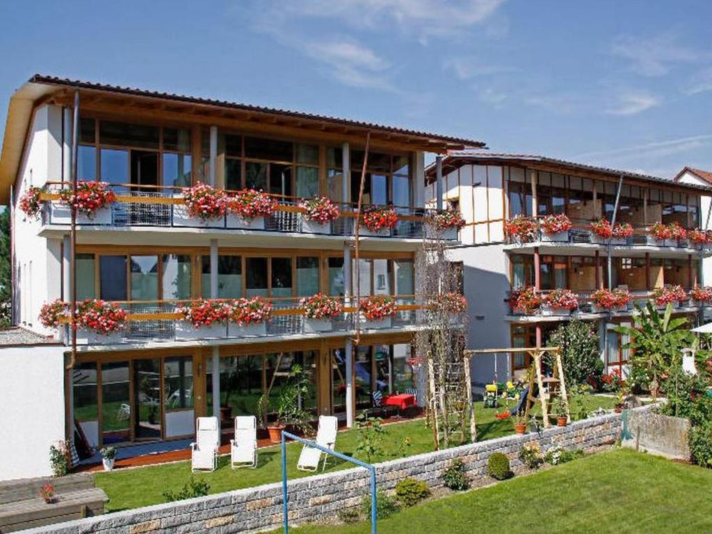 un gran edificio con macetas en los balcones en Appartement Hotel Seerose, en Immenstaad am Bodensee