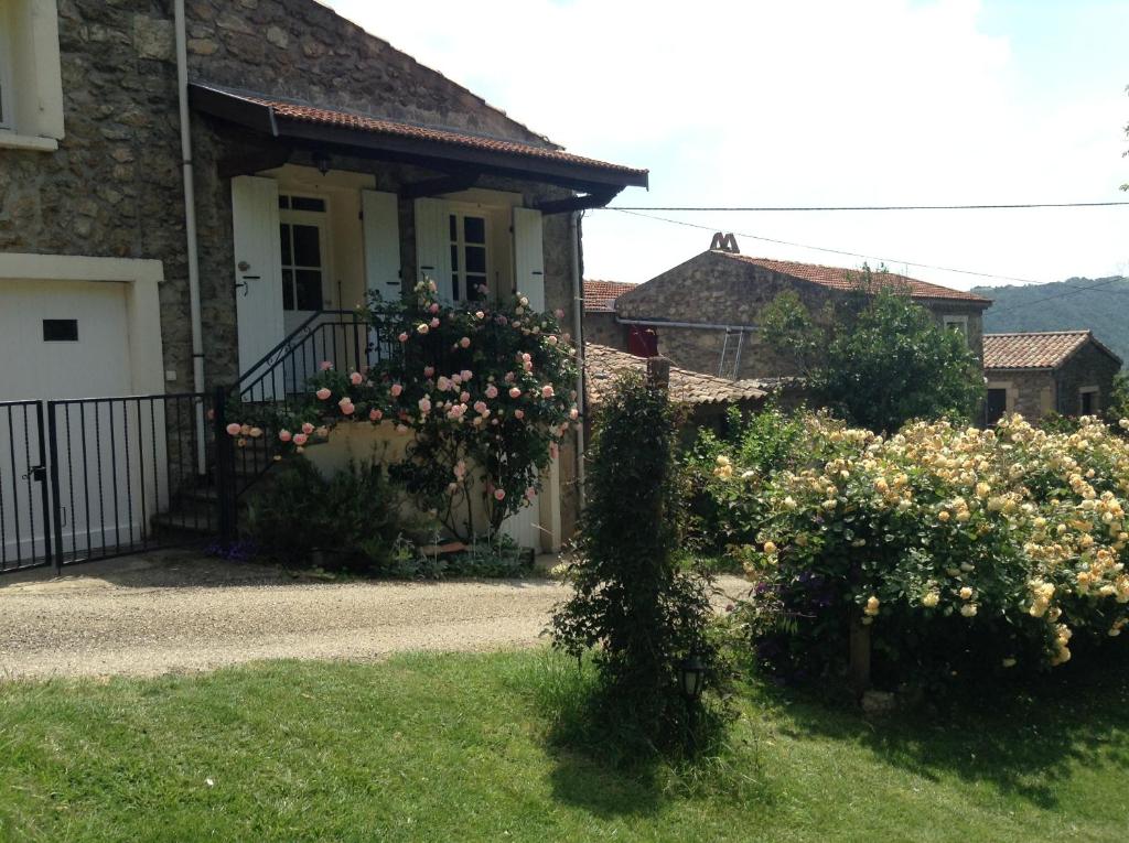 una casa con fiori di fronte a un cortile di le Vitrier a Saint-Jean-de-Muzols