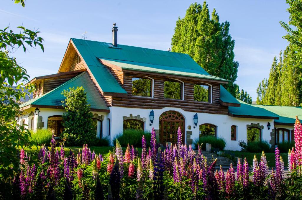 a house with flowers in front of it at Kau Yatún Hotel Boutique in El Calafate