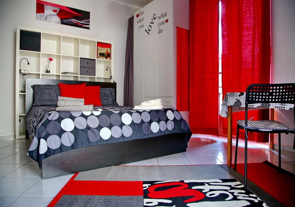 ミラノにあるBnButler - Col di Lana - Navigli Apartment - Darsenaのベッドルーム1室(ベッド1台、赤いカーテン付)