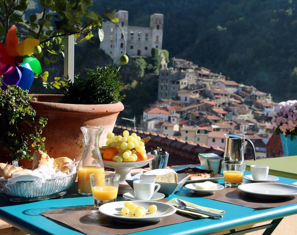 una mesa con platos de comida y vistas a la ciudad en Talking Stones en Dolceacqua