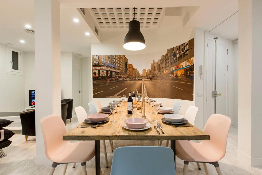 a dining room with a long table and white chairs at Book in Madrid - Cascorro Deluxe in Madrid