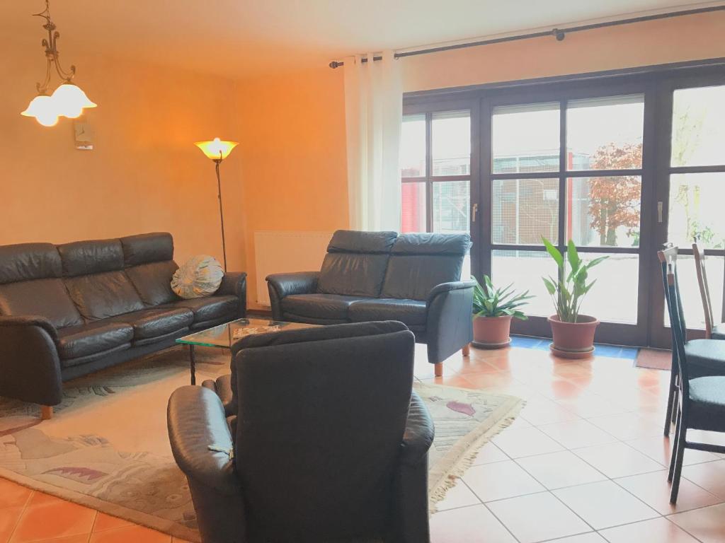 a living room with a leather couch and chairs at Ferienwohnung Rhönblick in Fulda