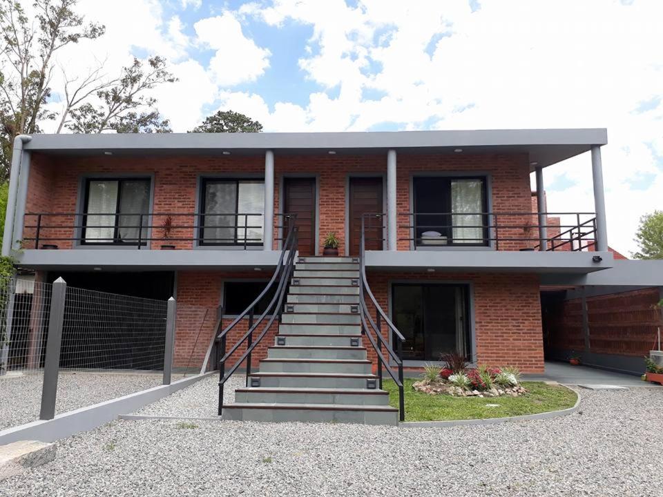 a red brick house with stairs in front of it at Los cardenales 2 in Santa Ana